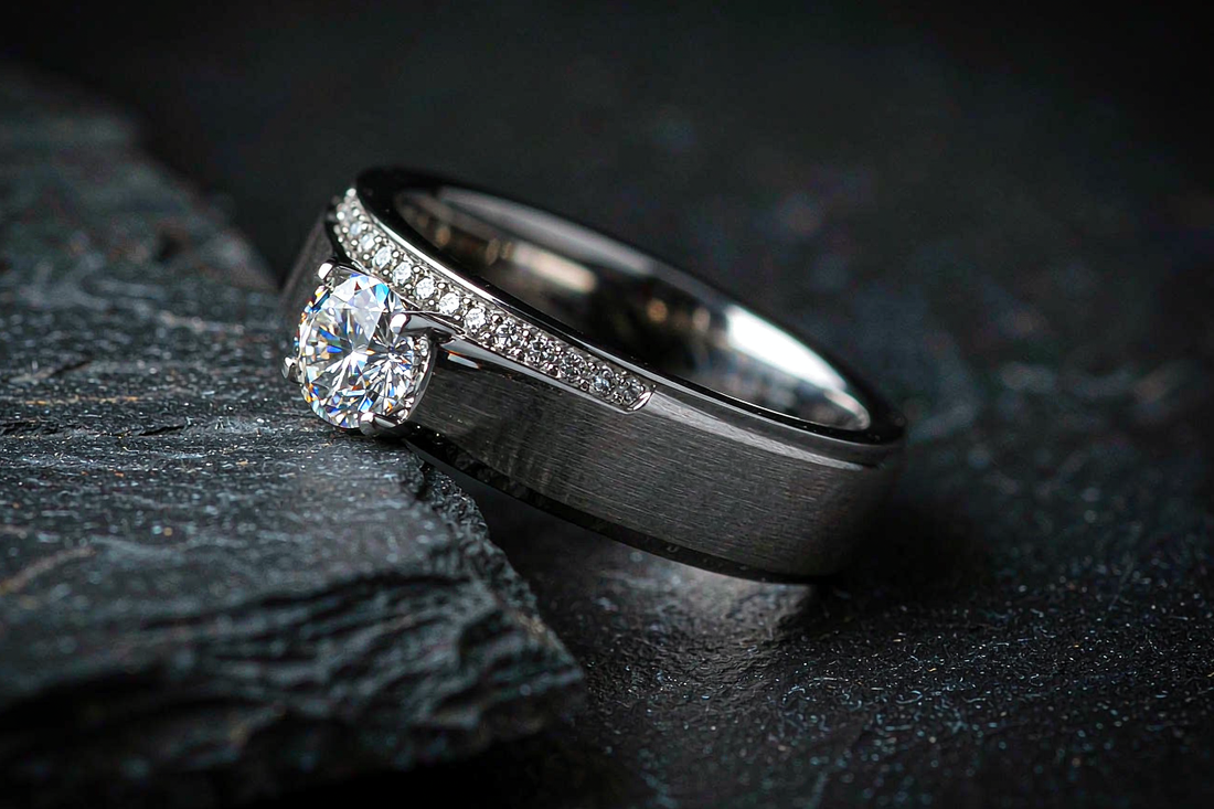 men's moissanite wedding band with channel set accent stones on dark slate background dramatic side lighting